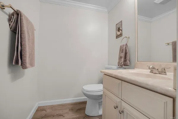 a bathroom with a granite countertop sink and a toilet