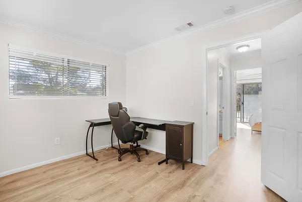 a view of a workspace with furniture and a window