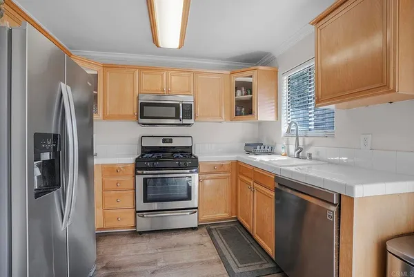a kitchen with stainless steel appliances a stove a sink and a refrigerator