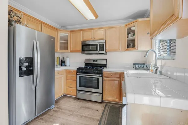 a kitchen with stainless steel appliances granite countertop a refrigerator stove and a sink