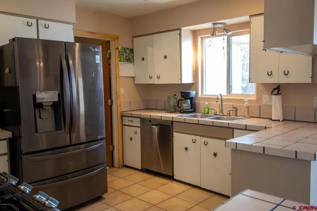 a kitchen with granite countertop a refrigerator and a sink