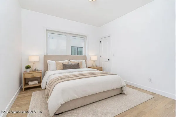a large bed sitting in a bedroom next to a window