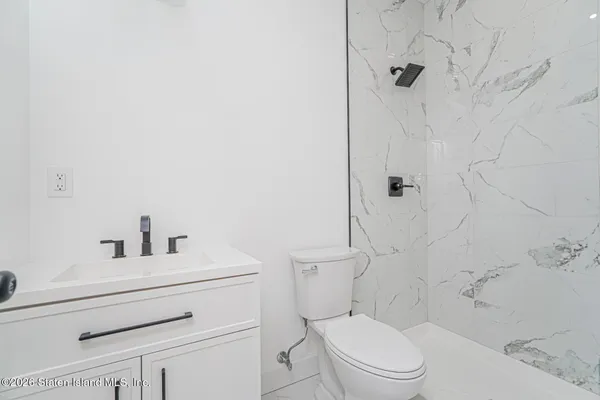 a bathroom with a toilet sink vanity and shower