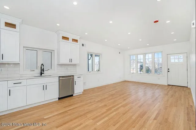 a large kitchen with a wooden floor and white cabinets