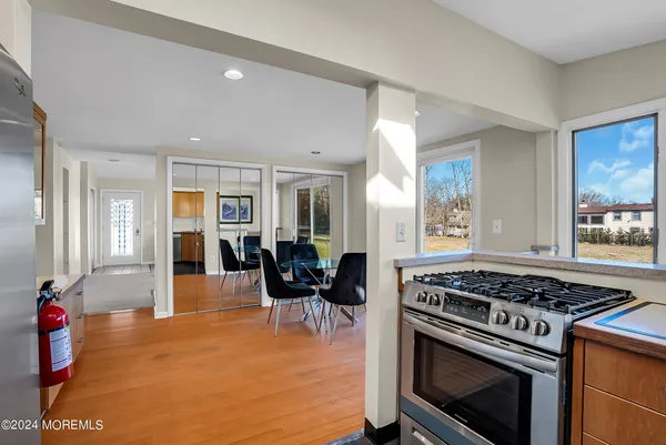 a kitchen with stove and chairs