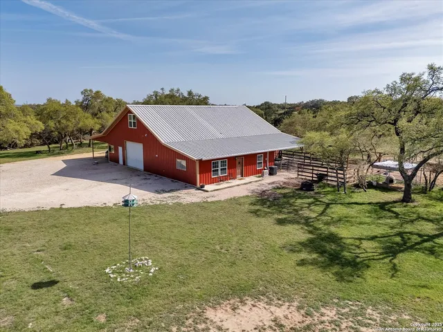 a aerial view of a house with swimming pool and a yard