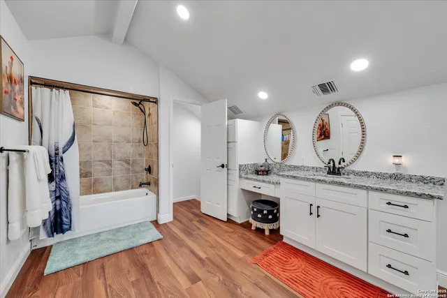 a large white kitchen with cabinets a sink a window and stainless steel appliances