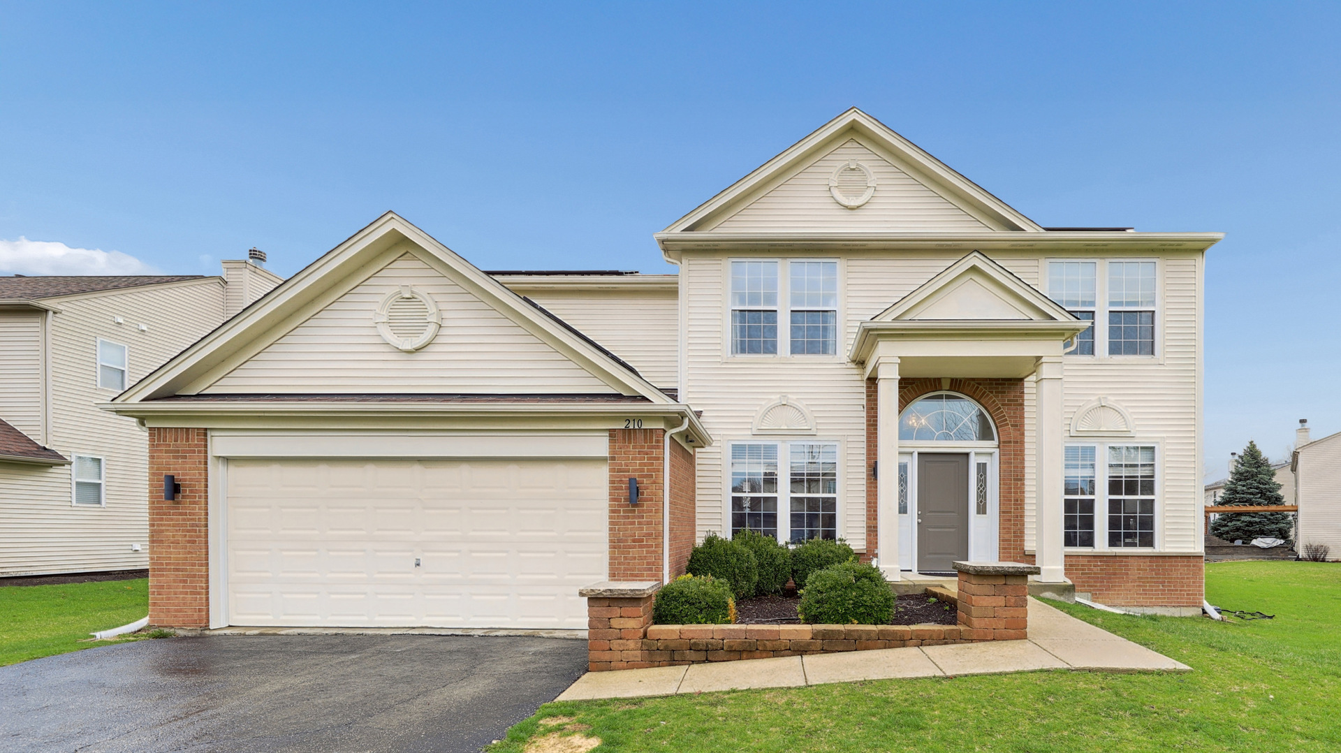 a front view of a house with a yard and garage