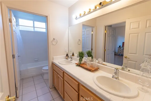 a bathroom with a double vanity sink a mirror and a bathtub