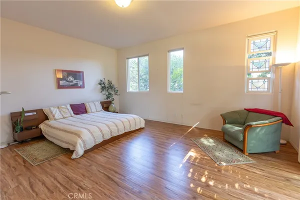 a bedroom with a bed and wooden floor