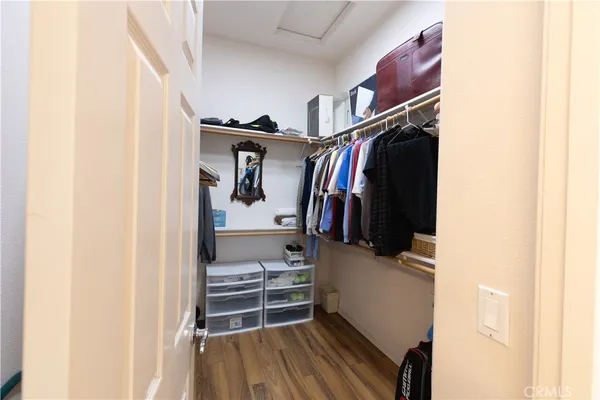 a view of walk in closet with clothes and shoes
