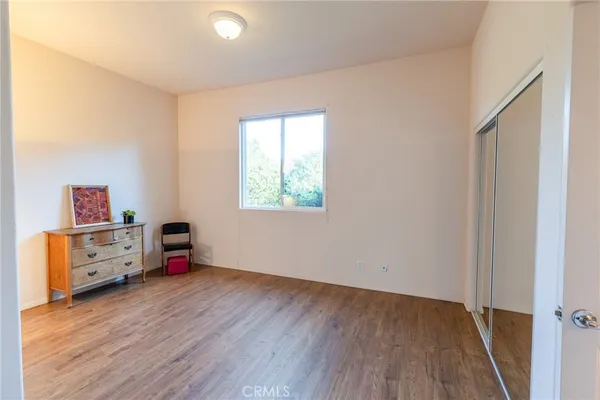 an empty room with a window and wooden floor