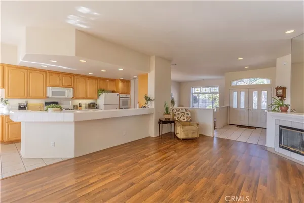 a kitchen with a sink wooden floor dining table chairs and view living room