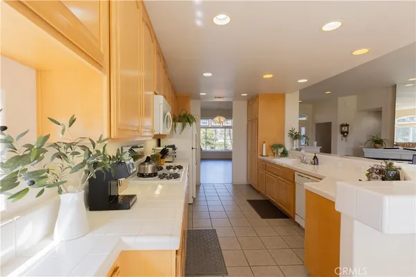 a large white kitchen with lots of counter top space and living room