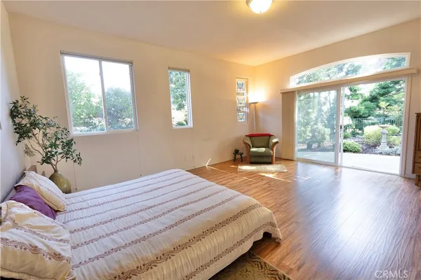 a bedroom with a bed and large windows