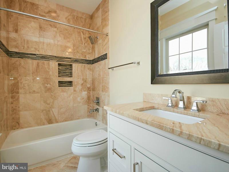 6000 27th Street North Arlington, VA 22207 - Photo 22 of 30 a bathroom with a granite countertop sink toilet and shower
