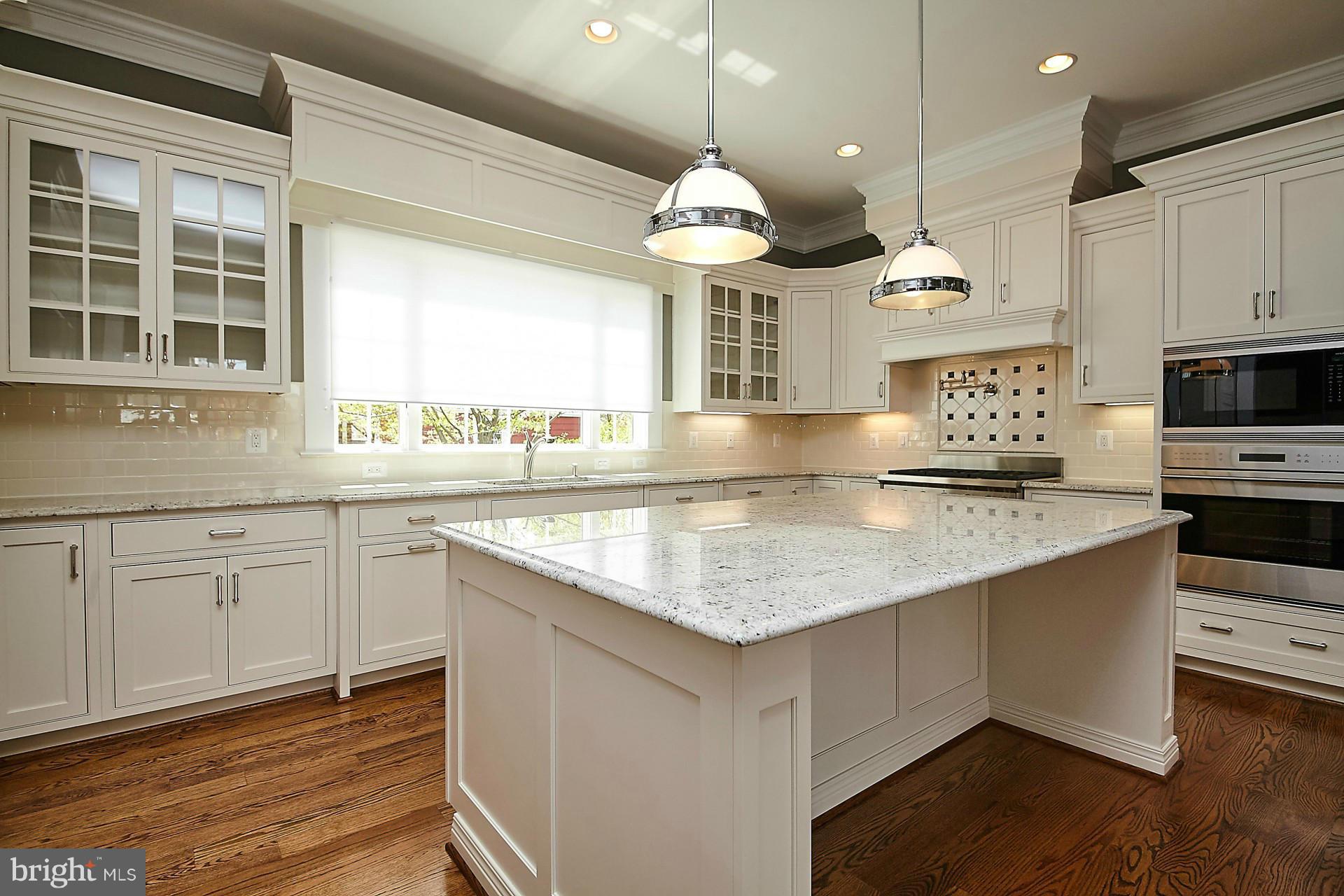 6000 27th Street North Arlington, VA 22207 - Photo 8 of 30 a kitchen with kitchen island granite countertop a stove a sink and a wooden cabinets