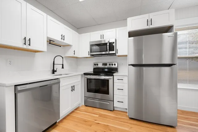 a kitchen with stainless steel appliances a refrigerator stove and microwave