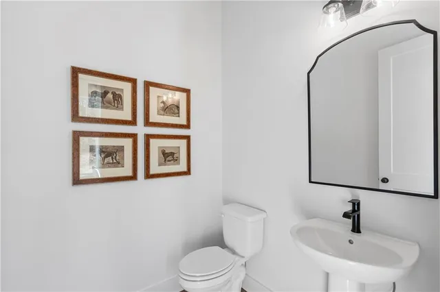 a bathroom with a toilet a sink and mirror
