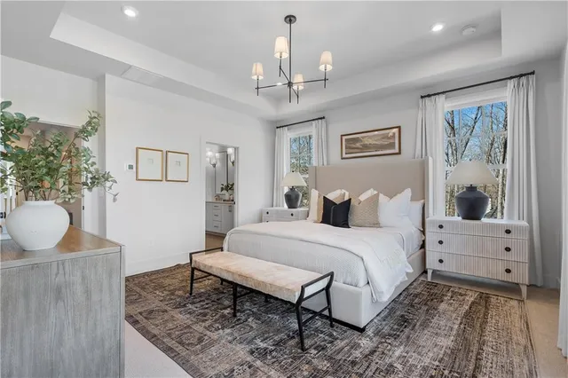 a spacious bedroom with a bed and a chandelier