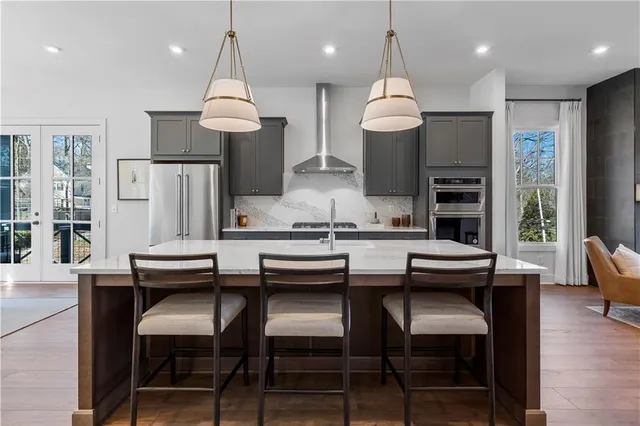 a dining room with wooden floor a chandelier a wooden table and chairs