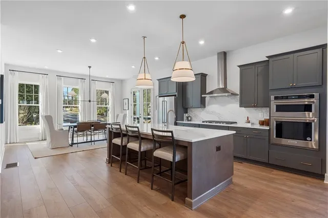 a kitchen with stainless steel appliances granite countertop a stove oven and a wooden floors