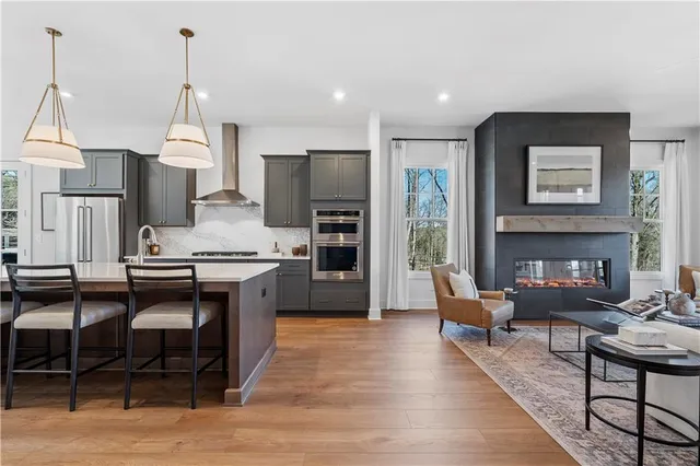 a living room with furniture a fireplace and kitchen view