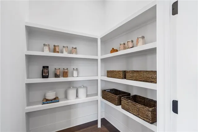 a kitchen with white cabinets and a wooden floor
