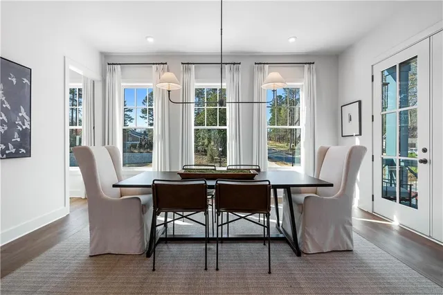 a dining room with wooden floor a glass table and chairs