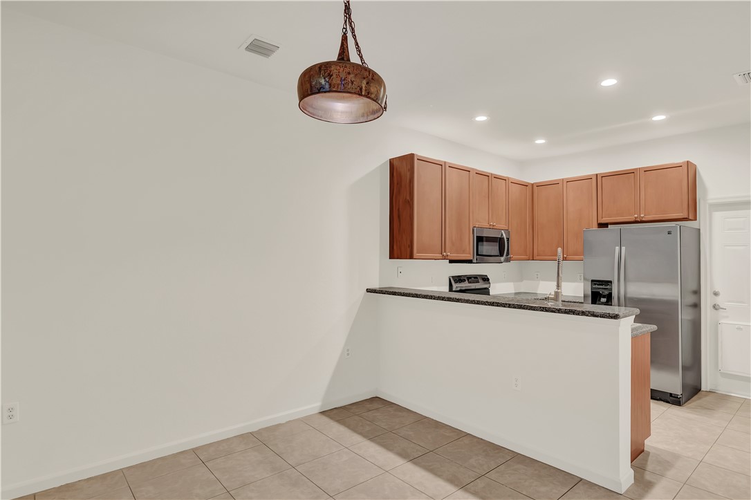 2541 Stockbridge Square Southwest Vero Beach, FL 32962 - Photo 12 of 33 a kitchen with stainless steel appliances granite countertop a refrigerator sink and cabinets
