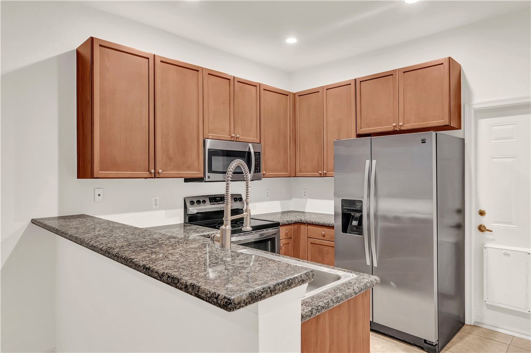 2541 Stockbridge Square Southwest Vero Beach, FL 32962 - Photo 13 of 33 a kitchen with stainless steel appliances granite countertop a refrigerator a stove microwave and sink