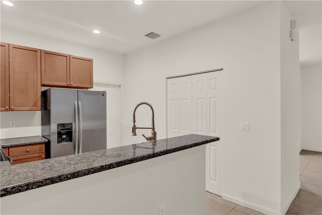 2541 Stockbridge Square Southwest Vero Beach, FL 32962 - Photo 14 of 33 a kitchen with stainless steel appliances granite countertop a sink a refrigerator and a granite counter tops