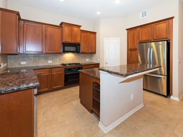 a kitchen with stainless steel appliances granite countertop a stove a sink and a microwave