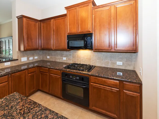 a kitchen with stainless steel appliances granite countertop a sink stove and cabinets