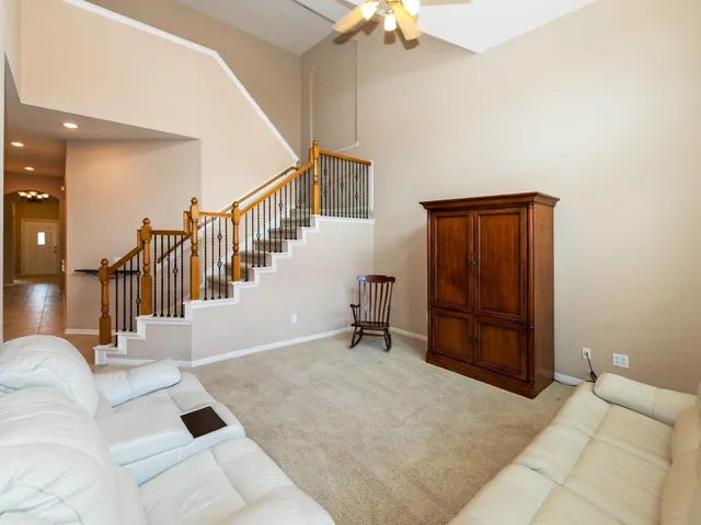 an empty room with windows and ceiling fan