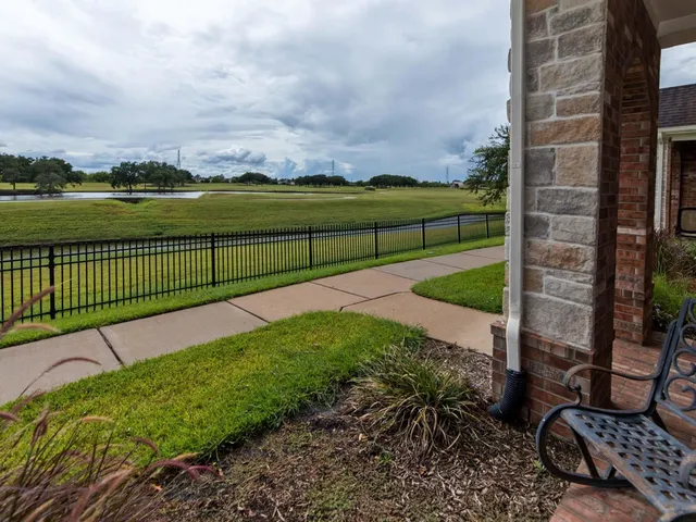 a view of a garden with a bench in front of house