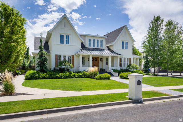 630 East Center Street Alpine, UT 84004 - Photo 4 of 115 White exterior featuring board-and-batten siding, a dark pitched roof, and a covered front porch with columns