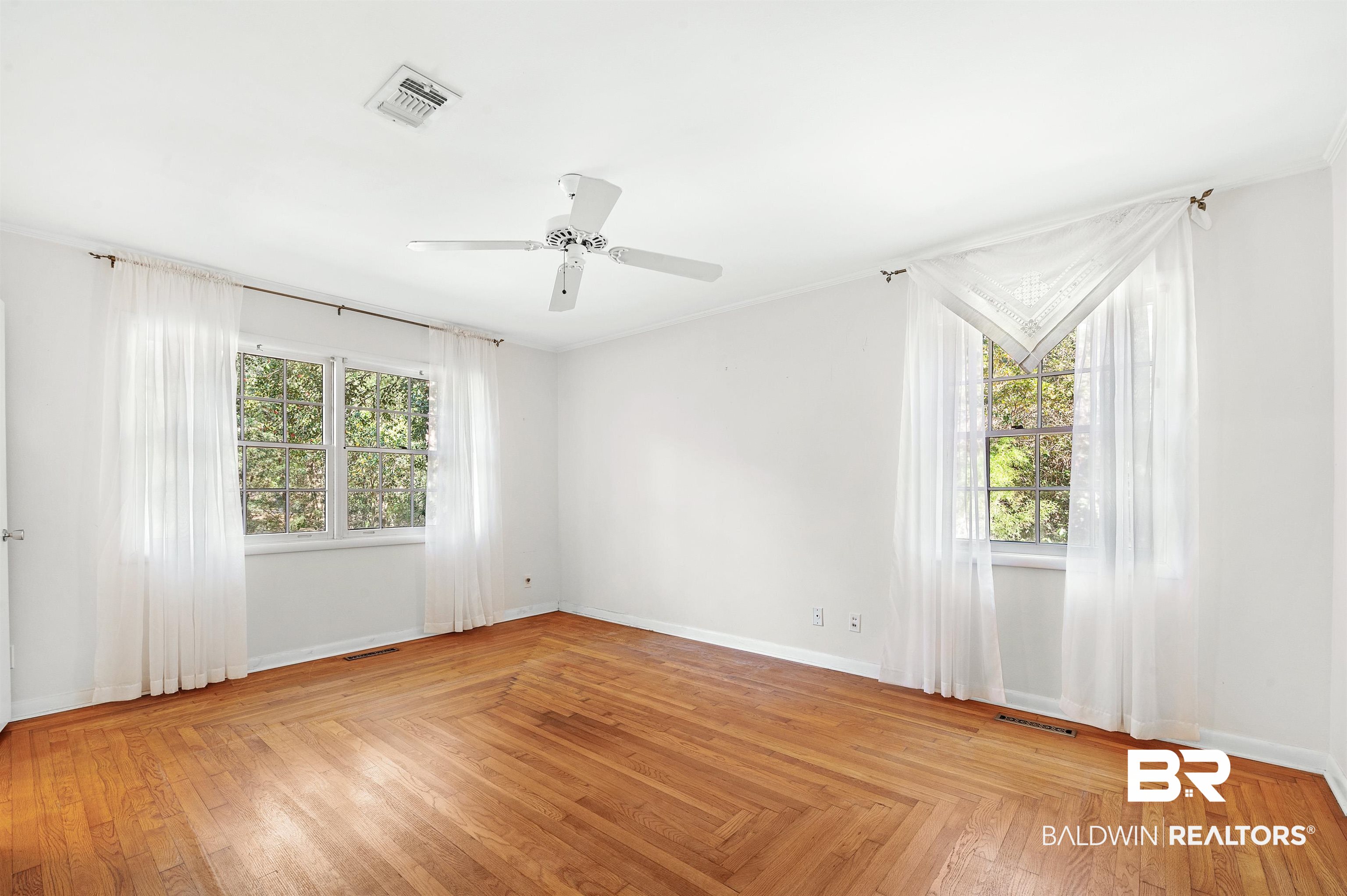 14375 Oak Street Magnolia Springs, AL 36555 - Photo 16 of 20 Unfurnished bedroom with cottage patterned oak hardwood floor and ceiling fan