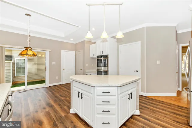 a view of a kitchen with refrigerator and wooden floor