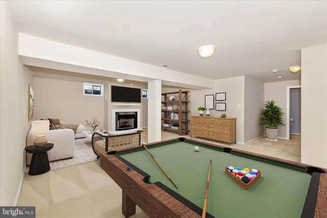 a view of a white house next to a yard with big trees