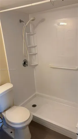 a bathroom with a toilet and a shower