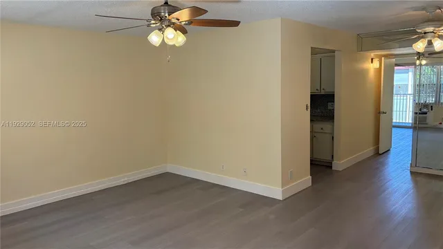 a view of empty room with wooden floor