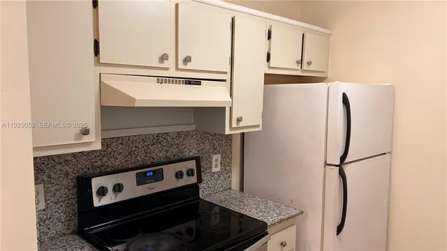 a kitchen with stainless steel appliances granite countertop a refrigerator and a stove