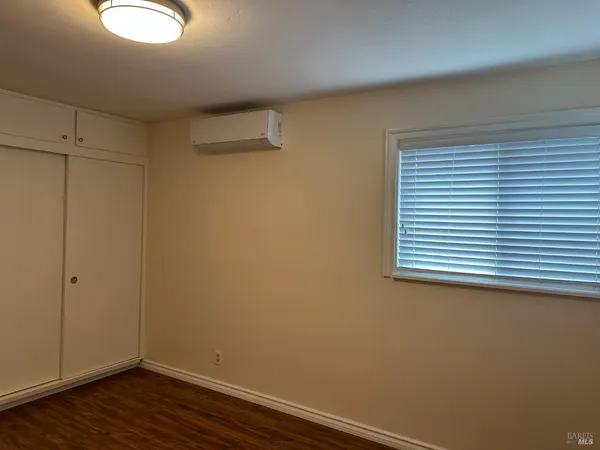 a view of a small space with wooden floor and a window