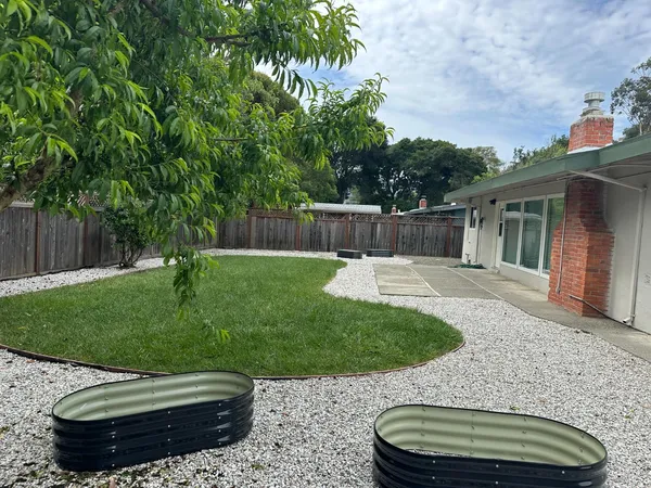 a view of a backyard with a garden and entertaining space