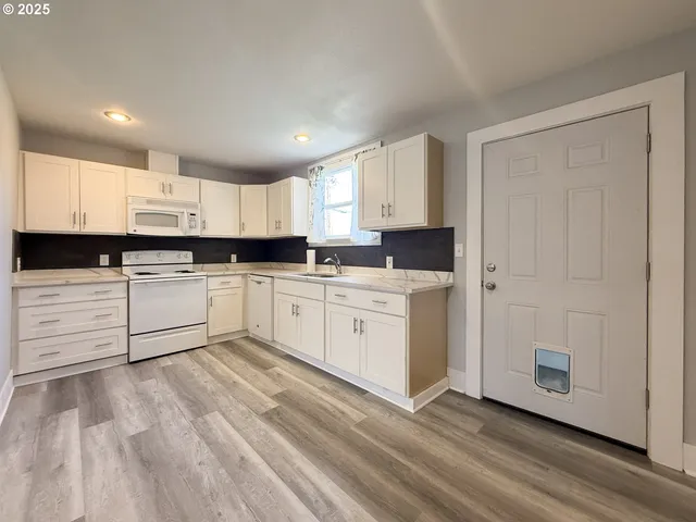 a kitchen with white cabinets stainless steel appliances and sink