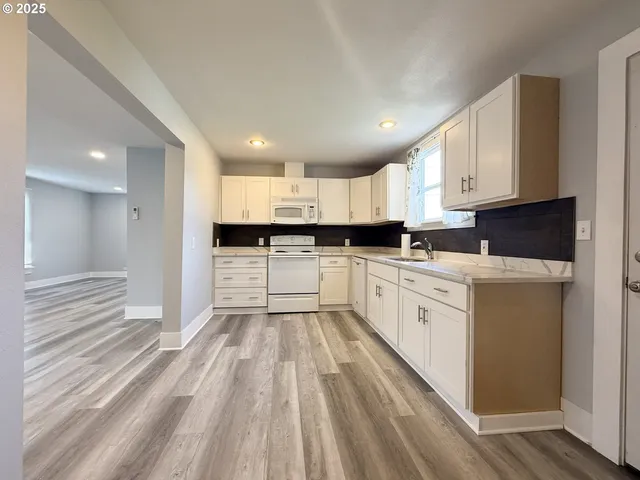 a large white kitchen with cabinets
