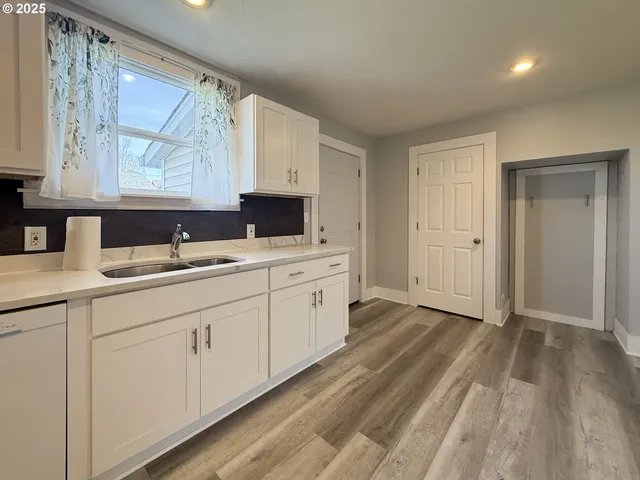 a kitchen with white cabinets and sink