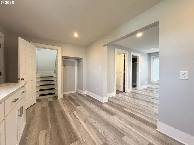 a view of a hallway with wooden floor and closet