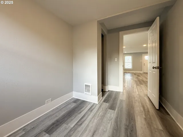 a view of a room with wooden floor and a window